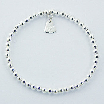 Sterling Silver bracelet with continuous 4mm balls featuring a flat heart charm. A timeless bead bracelet with high polish finish.