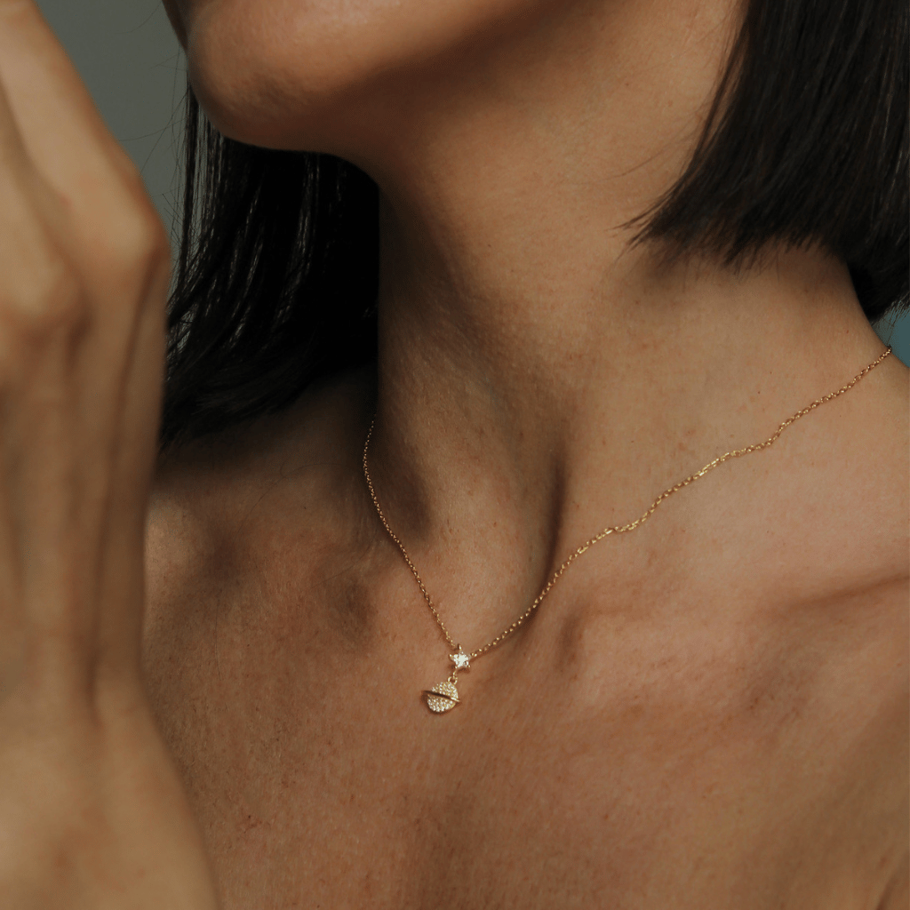 Gold necklace featuring a tiny star with orbit drop charm on a gold chain.