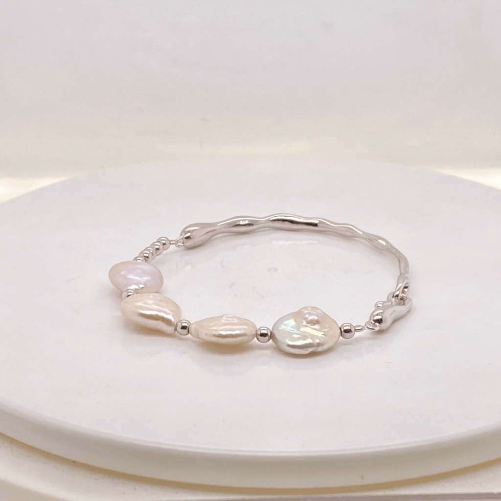 Freshwater pearl bangle featuring four flat baroque pearls in sterling silver.