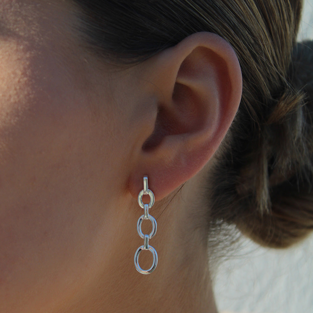Solid Sterling Silver high polished ladies drop earrings. Three circle that interlink with a statement drop.