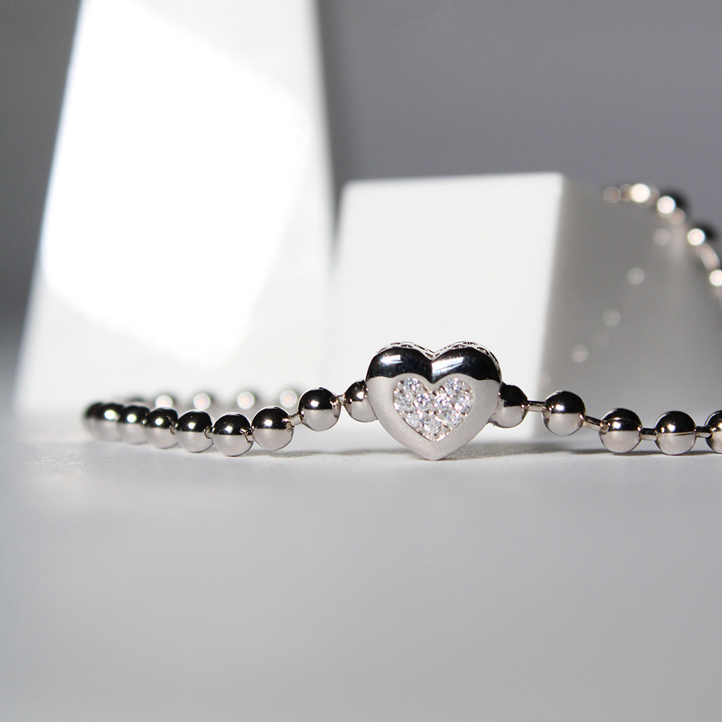 Sterling silver with a high polish finish. Featuring a love heart encrusted with cubic zirconia stones and continuous beads.