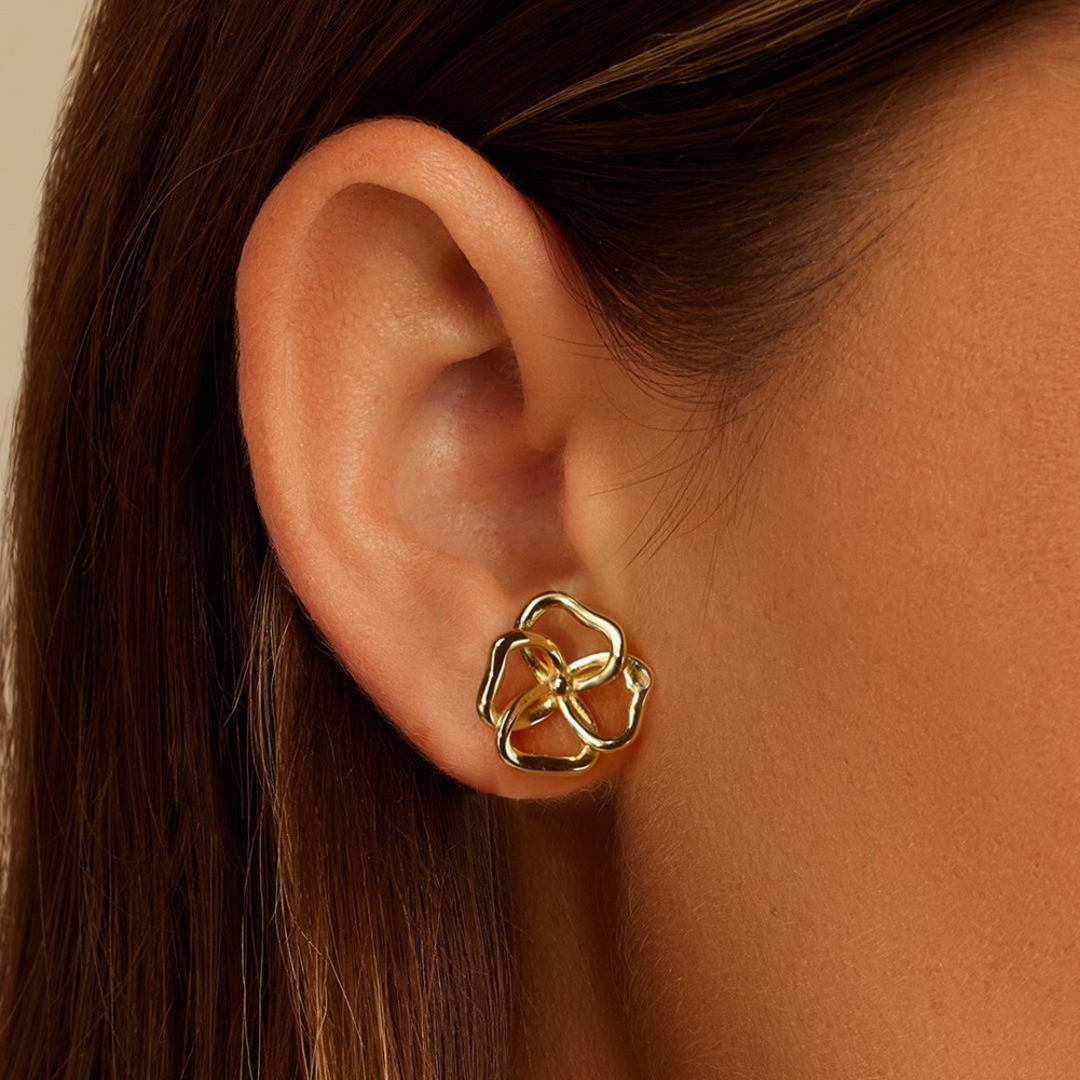 Model wearing gold plated abstract bloom stud earrings