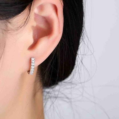 Huggie hoop earrings with sparkling cubic zirconia stones in sterling silver.